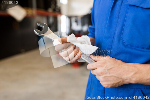 Image of auto mechanic or smith with wrench at car workshop