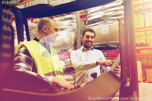 Image of happy men with tablet pc and forklift at warehouse