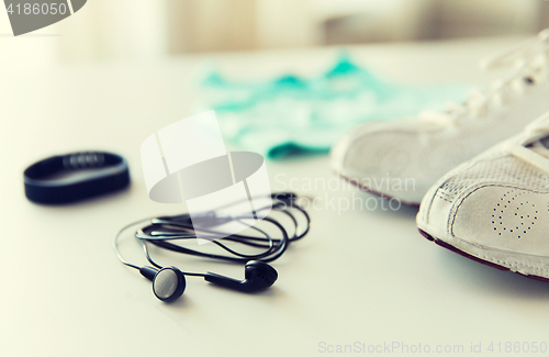 Image of close up of earphones, bracelet and sportswear