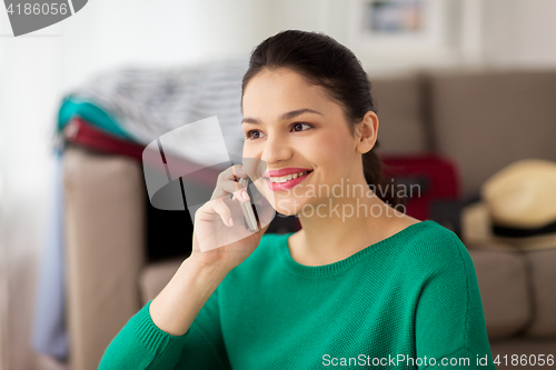 Image of happy woman calling on smartphone at home