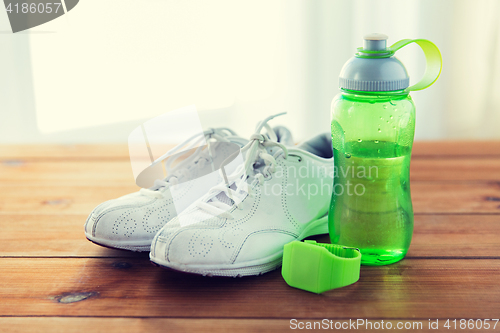 Image of close up of sneakers, bracelet and water bottle