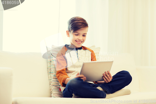 Image of smiling boy with tablet computer at home