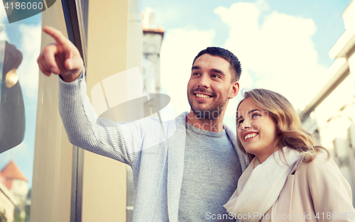 Image of happy couple shopping and looking at shop window