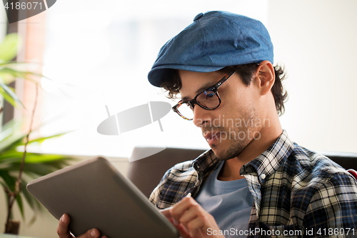 Image of close up of man with tablet pc sitting at cafe