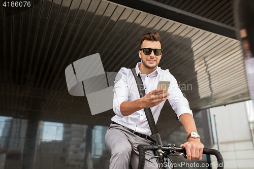 Image of man with bicycle and smartphone on city street