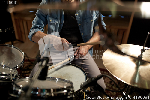 Image of male musician playing drums and cymbals at studio