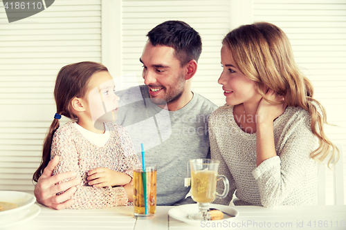 Image of happy family having dinner at restaurant or cafe