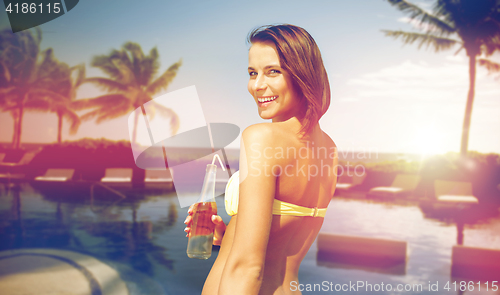 Image of happy woman with bottle of drink on summer beach