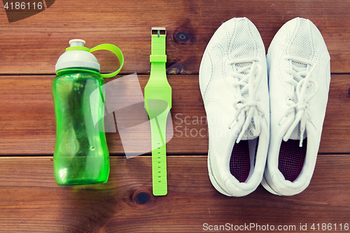 Image of close up of sneakers, bracelet and water bottle