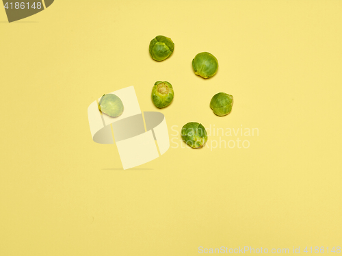 Image of The piles of Brussels sprouts on a yellow background