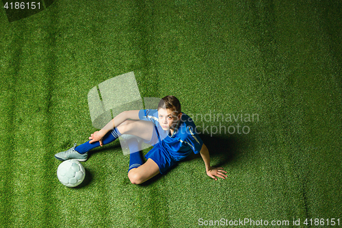 Image of Boy soccer player sitting on greeb grass