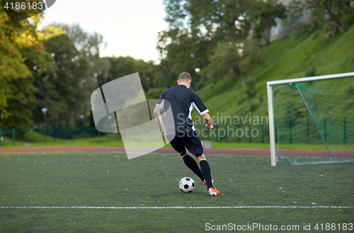 Image of soccer player playing with ball on football field