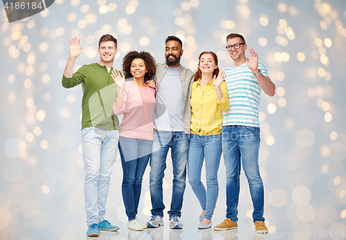 Image of international group of happy people waving hands