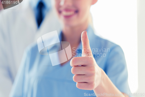 Image of close up of doctor or nurse showing thumbs 