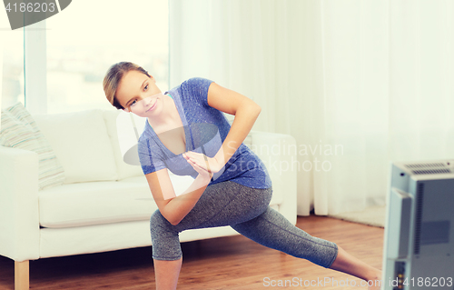 Image of woman making yoga low angle lunge pose on mat