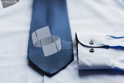 Image of close up of shirt and blue patterned tie