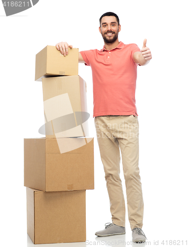 Image of happy man with cardboard boxes showing thumbs up