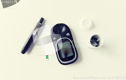 Image of close up of glucometer and blood sugar test stripe