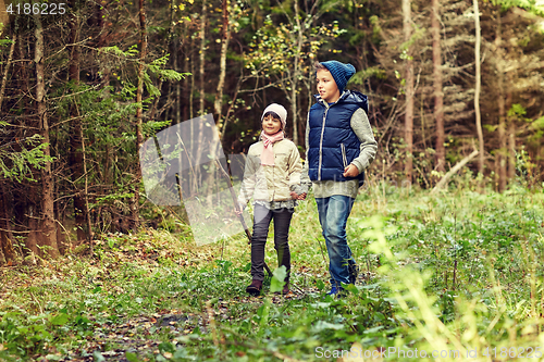 Image of two happy kids walking along forest path