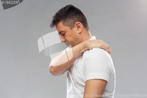 Image of unhappy man suffering from pain in shoulder