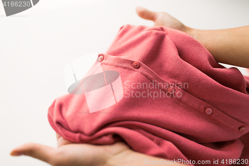 Image of close up of hands with clothing item or cardigan