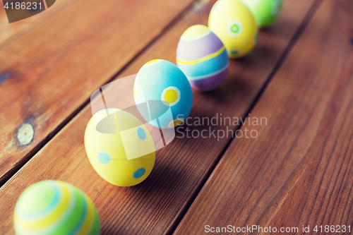 Image of close up of colored easter eggs on wooden surface