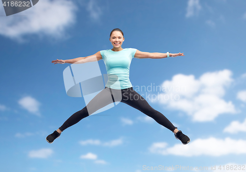 Image of happy smiling sporty young woman jumping in air