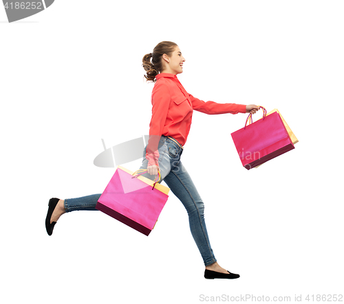 Image of smiling young woman with shopping bags running