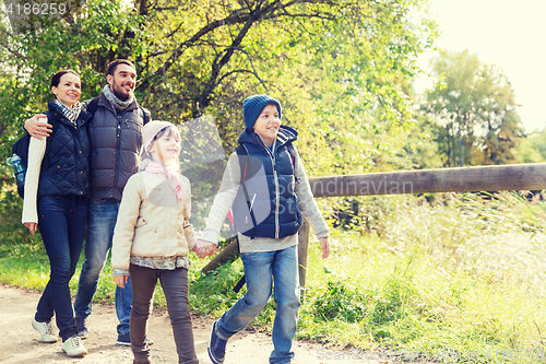 Image of happy family with backpacks hiking in woods