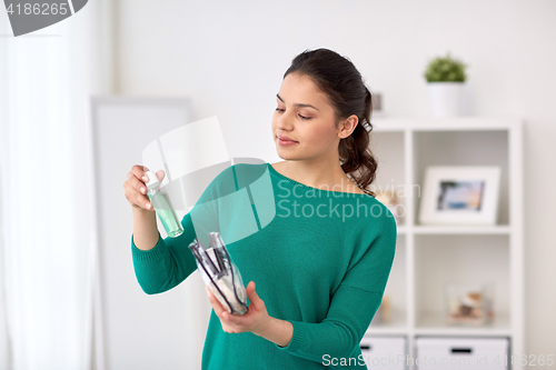 Image of woman packing cosmetics to cosmetic bag at home