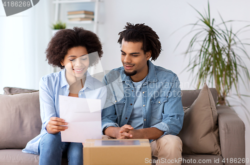 Image of happy couple with parcel box and paper form home