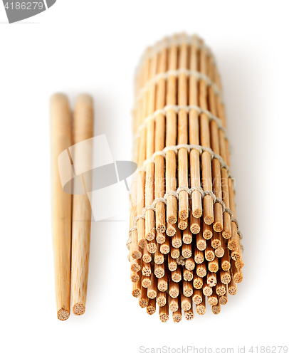 Image of Sushi mat foldered and chopsticks near