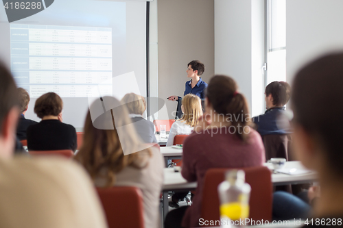 Image of Woman giving presentation in lecture hall at university.