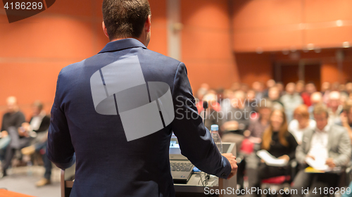 Image of Public speaker giving talk at Business Event.