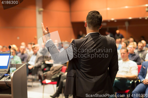 Image of Public speaker giving talk at business event.