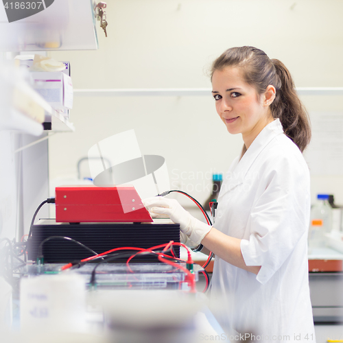 Image of Life science researcher setting voltege on power supply to run electrophoresis.