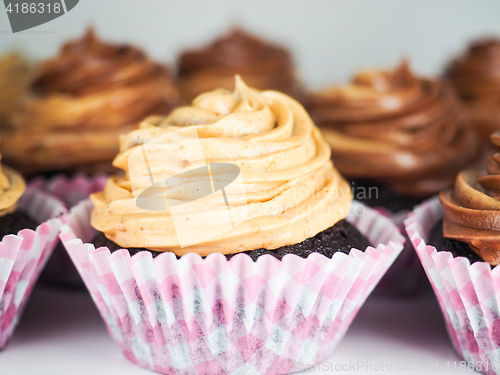 Image of Chocolate cupcake with mixed frosting cream, in pink paper cups