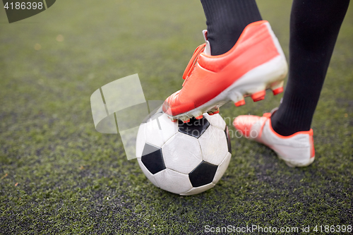 Image of soccer player playing with ball on football field