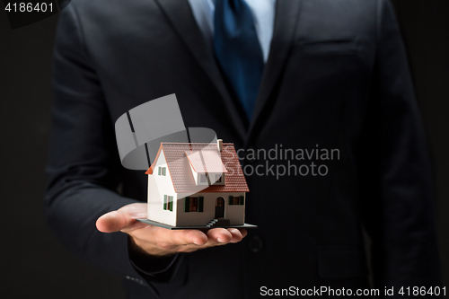 Image of close up of businessman holding house model