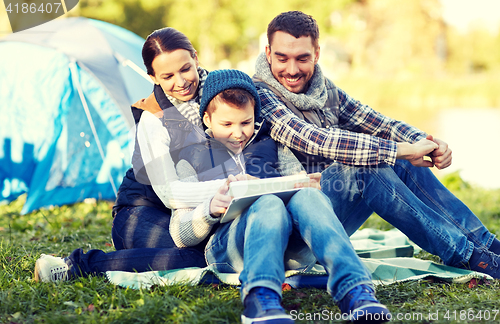 Image of happy family with tablet pc and tent at camp site