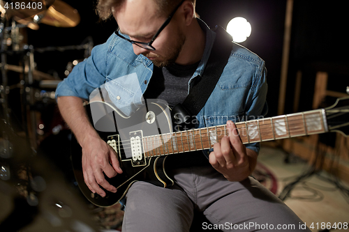 Image of man playing guitar at studio rehearsal