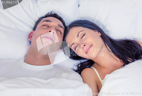 Image of happy couple sleeping in bed