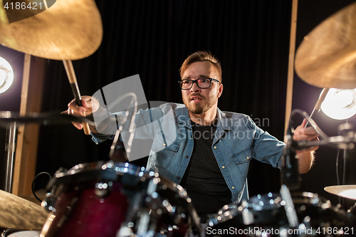 Image of male musician playing drums and cymbals at concert