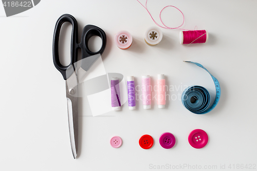 Image of scissors, sewing buttons, threads and tape measure