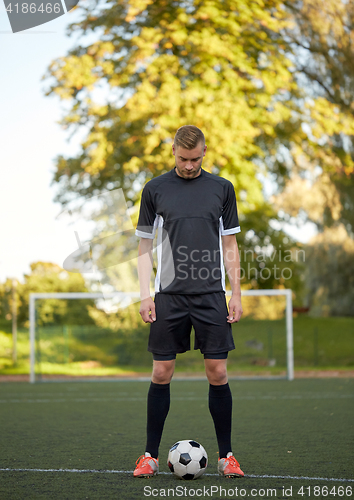 Image of soccer player playing with ball on football field