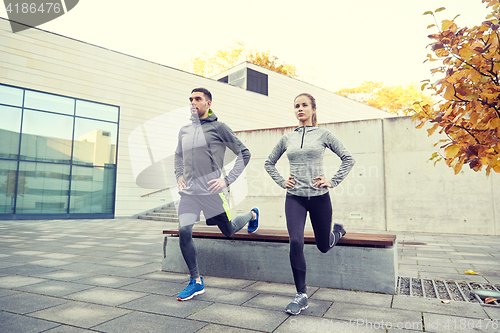 Image of couple doing lunge exercise on city street