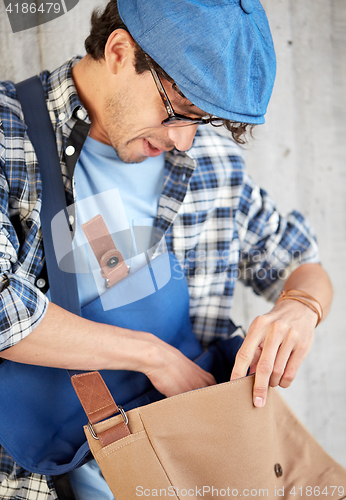 Image of close up of hipster man looking into his bag