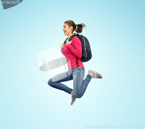 Image of happy woman or student with backpack jumping