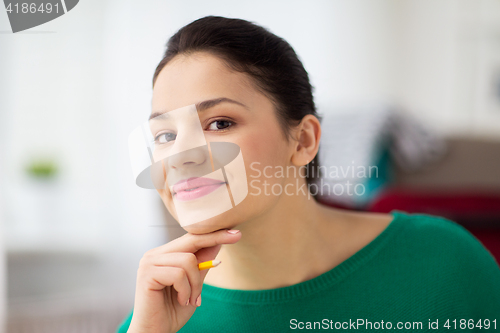 Image of happy young woman with pencil thinking