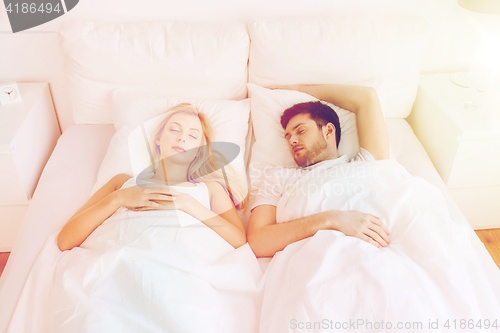 Image of happy couple sleeping in bed at home